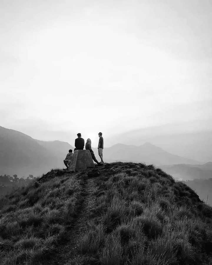 Friends standing together on a misty hilltop